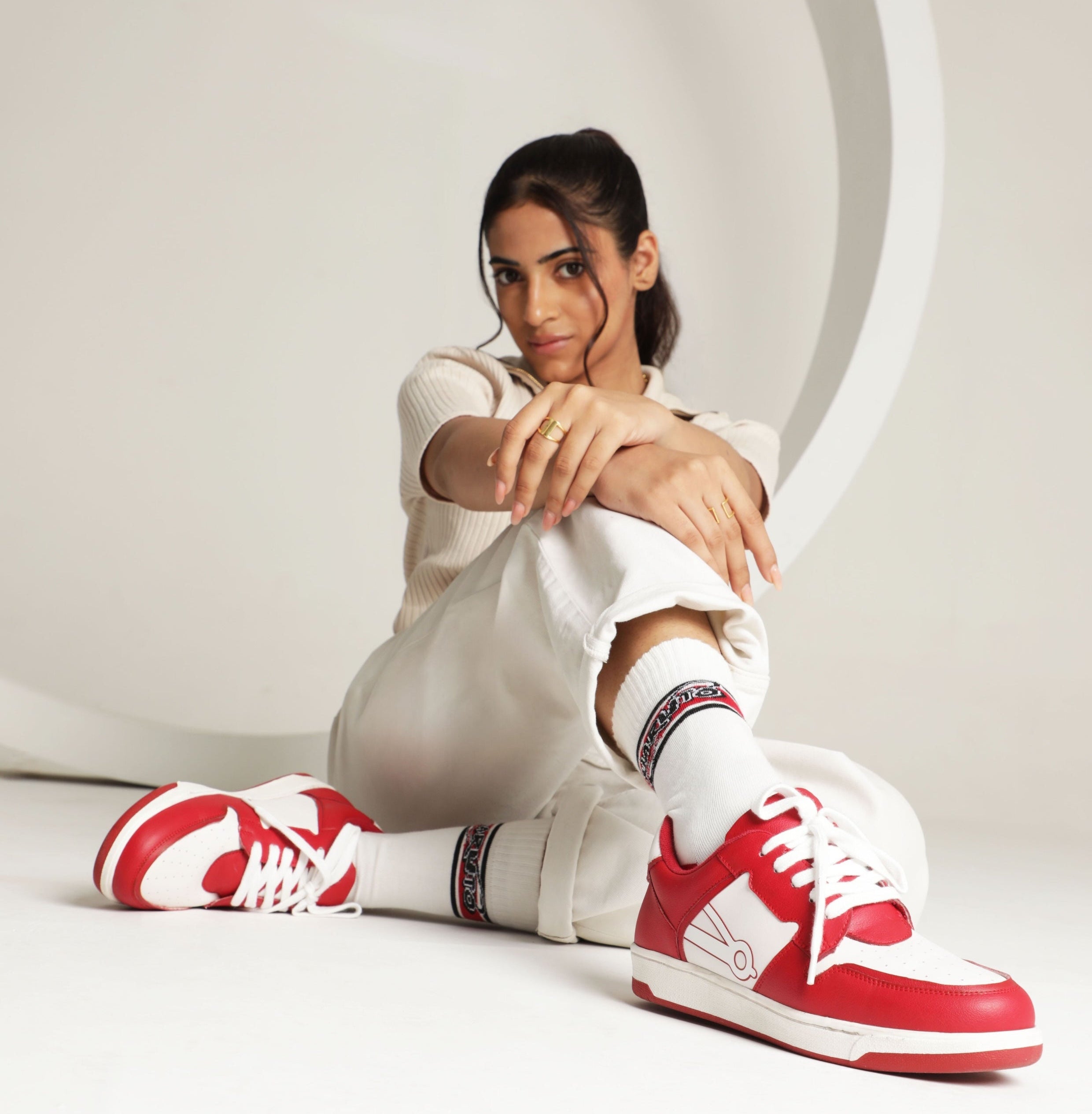 Person wearing red and white sneakers with a white background